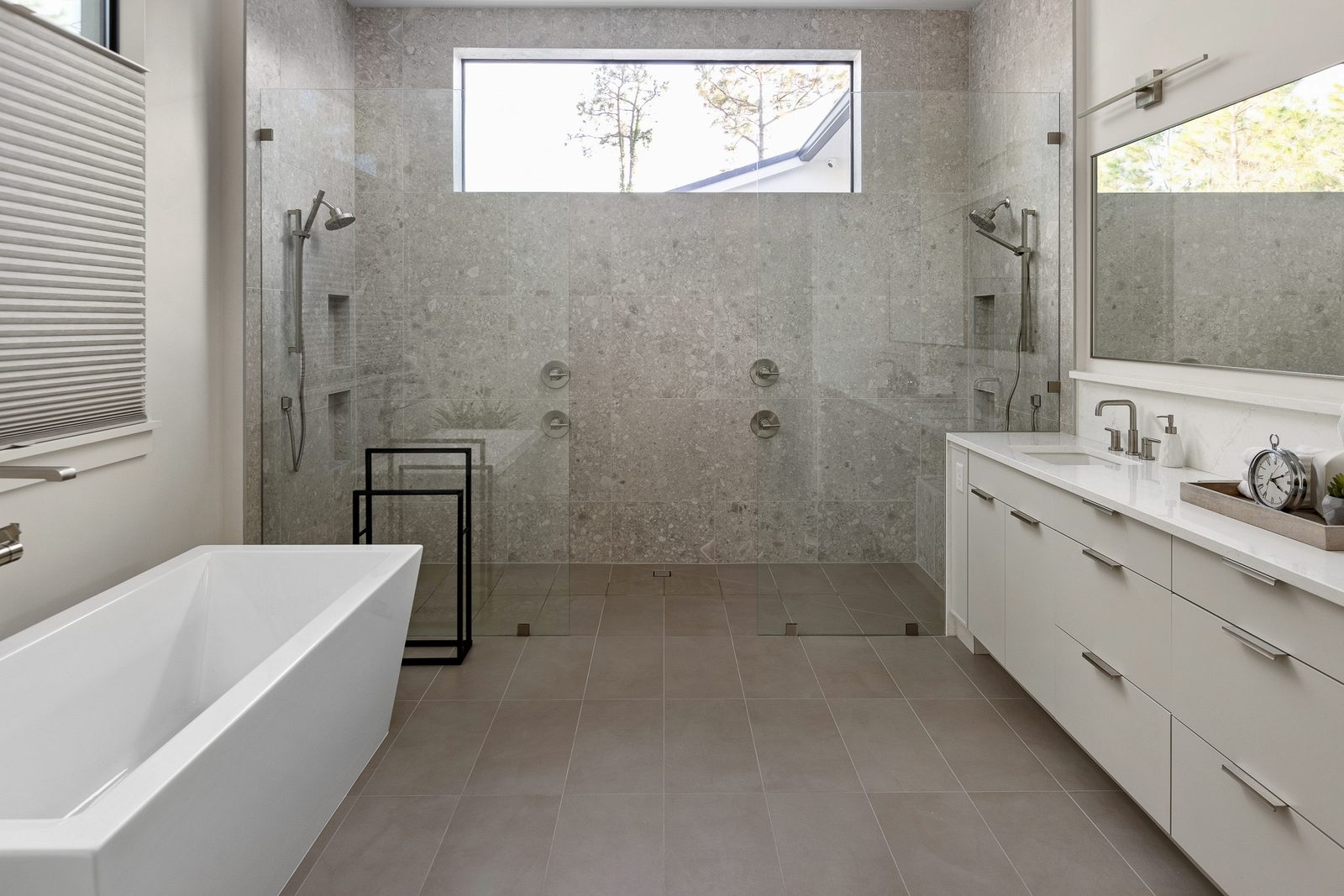 Bella Collina master bath with curbless walk-in shower, large-format terrazzo-look porcelain walls, dual showers, and freestanding tub